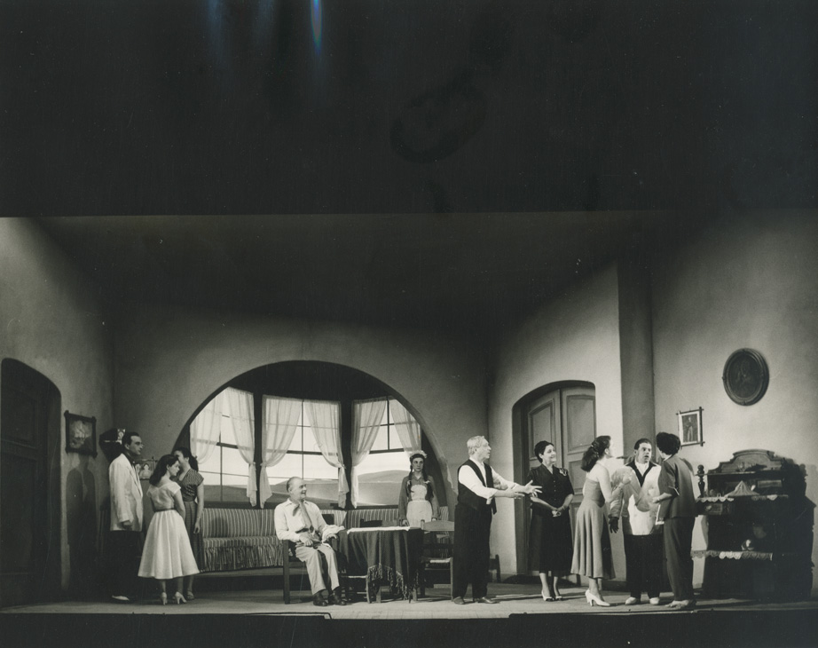 Σκηνή από τις Φουσκοθαλασσιές (1937) του Δημήτρη Μπόγρη, σε παραγωγή του Εθνικού Θεάτρου στο Δημοτικό Θέατρο Πειραιά (1954). Ο καπετάν Νικολής Σφακιανός επιστρέφει στο νησί του ύστερα από χρόνια στη θάλασσα και συγκρούεται με τη γυναίκα του, που θέλει να παντρέψει τις κόρες τους με στεριανούς. Οι ναυτικοί και νησιώτικοι τύποι του έργου συνθέτουν χαρακτηριστικό δείγμα θαλασσινής ηθογραφίας.&nbsp;
