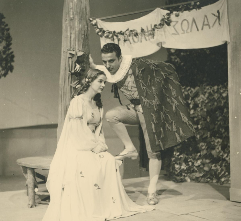 William Shakespeare, Το χειμωνιάτικο παραμύθι [The Winter's Tale, 1611], Εθνικό Θέατρο, Κεντρική Σκηνή (Κτήριο Τσίλλερ), Αθήνα, θεατρική περίοδος 1952-1953, σε σκηνοθεσία [[#Αλέξη Σολομού#]], μετάφραση [[#Βασίλη Ρώτα#]] και σκηνικά / κοστούμια [[#Σπύρου Βασιλείου [Spyros Vassiliou]#]] (φωτογραφία: Émile). Στο στιγμιότυπο εικονίζονται η Αντιγόνη Βαλάκου ως Περντίτα και ο [[#Ηλίας Σταματίου#]] ως Φλοριζέλ, ζεύγος που ενσαρκώνει στο σαιξπηρικό έργο το αρχετυπικό σχήμα της ενζενύ και του ζεν πρεμιέ: η αγνή βοσκοπούλα-βασιλοπούλα και ο νεαρός πρίγκιπας-εραστής, φορείς της ποιμενικής αναγέννησης που σφραγίζει το τραγικοκωμικό φινάλε.