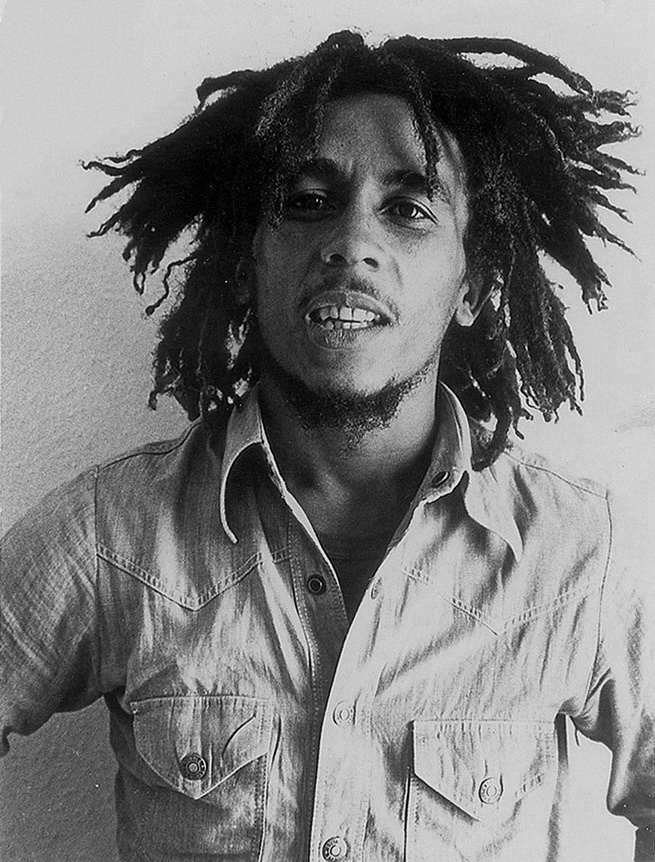 O [[#Bob Marley [Μπομπ Μάρλεϋ]#]] (1945-1981), η φωνή που καθιέρωσε το τζαμαϊκανό ρέγκε ως παγκόσμιο ιδίωμα με μηνύματα ειρήνης και κοινωνικής δικαιοσύνης, σε φωτογραφία Τύπου του 1976. Το τραγουδιστικό του ύφος συνδυάζει τη ρητορική παράδοση του κηρύγματος των Ρασταφάρι με τη φρασεολογία της αφροαμερικανικής σόουλ: μελωδική γραμμή που ακολουθεί τον ανάποδο τονισμό του ρυθμού, ρινική χροιά, μελίσματα μικρής έκτασης και διαρκής διάλογος της κύριας φωνής με τις γυναικείες φωνές των&nbsp;[[#I-Threes [Άι-Θρηζ]#]]. Το τραγούδι λειτουργεί εδώ ταυτόχρονα ως λατρευτική πράξη, ως αφήγηση και ως πολιτική διακήρυξη.