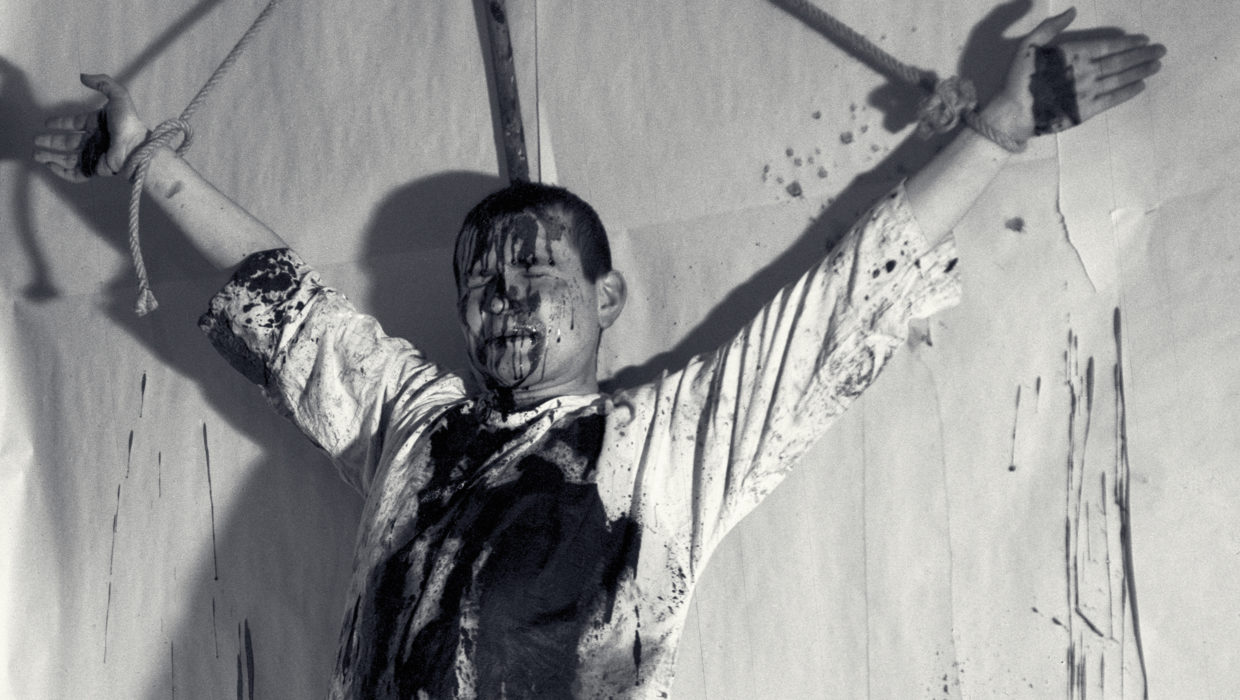 Hermann Nitsch, 1. Aktion [Δράση 1], 19 Δεκεμβρίου 1962, Βιέννη, Φωτογραφία: [[#Hans Niederbacher#]]. Λίγους μήνες μετά την πρώτη κοινή τους δράση (Die Blutorgel, 1962), κατά την οποία τα μέλη της ομάδας κρέμασαν ανάποδα στον τοίχο ένα σφαγμένο αμνό, ο Nitsch λουσμένος με αίμα που έρεε πάνω στο σώμα και το λευκό του ένδυμα, σταυρώνεται αυτή τη φορά ο ίδιος, στο σπίτι του Mühl. Η δράση αυτή ήταν μονάχα η αρχή παρόμοιων εκδηλώσεων που συνεχίζονται εδώ και πολλές δεκαετίες. Ενδεικτικά το 2020 παρουσιάστηκε η 128η (για την καταγραφή τους βλ. την ιστοσελίδα nitsch.org).   