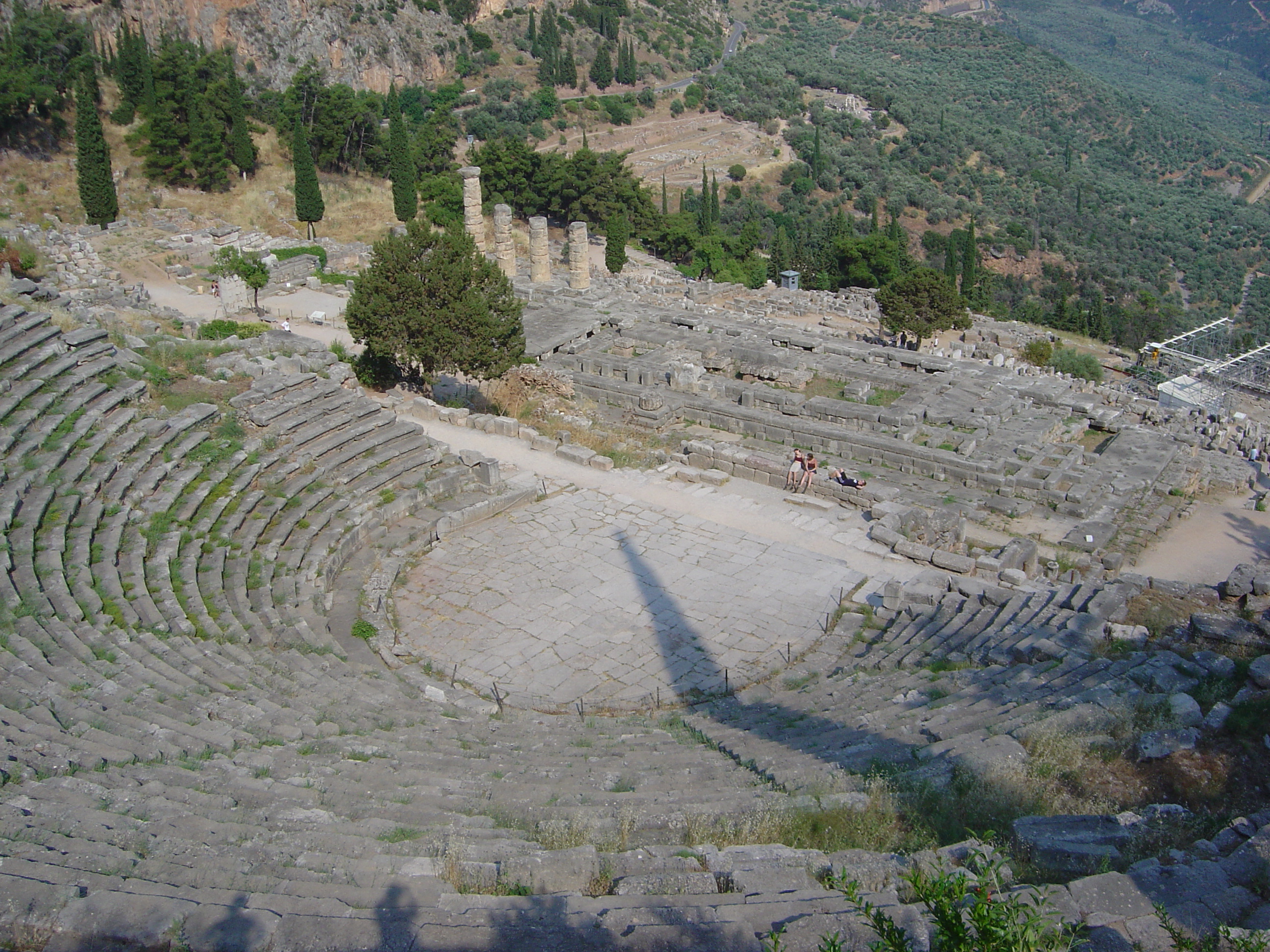 Η πεταλόσχημη ορχήστρα του αρχαίου θεάτρου των Δελφών, διαμέτρου 18,24 μ. (1η φάση: 2ος αι. π.Χ.). Κατά τους ρωμαϊκούς χρόνους &nbsp;επιστρώθηκε με ακανόνιστες λίθινες πλάκες.
