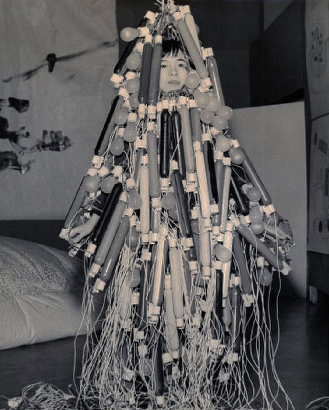 Ατσούκο Τανάκα, Ηλεκτρικό φόρεμα [Electric Dress], δεύτερη έκθεση Γκουτάι, Οκτώβριος 1956, Μέγαρο Οχάρα Καϊκάν, Τόκυο.  Το Ηλεκτρικό φόρεμα της Ατσούκο Τανάκα ζύγιζε περίπου 50 κιλά και αποτελούνταν από ένα συνονθύλευμα καλωδίων και 200 λυχνιών, βαμμένων από την ίδια. Η καλλιτέχνις με το έργο αυτό ενσαρκώνει τόσο την καταπίεση που υφίσταντο οι γυναίκες στη χώρα της, όσο και την ασφυκτική και ραγδαία τεχνολογική και δημογραφική ανάπτυξη της μεταπολεμικής Ιαπωνίας.   