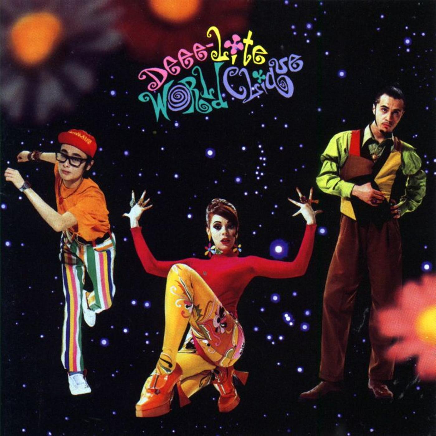 Εξώφυλλο του μουσικού άλμπουμ World Clique (1990) των [[#Deee-Lite [Ντηηη-Λάιτ]#]], με τη [[#Lady Miss Kier [Λέιντυ Μις Κηρ]#]] σε ψηλούς πορτοκαλί κοθόρνους. Το τρίο εισήγαγε στην ποπ σκηνή των αρχών της δεκαετίας του 1990 μια ψυχεδελική, κουήρ αισθητική, ανασημασιοδοτώντας τον κόθορνο ως σύμβολο εορταστικής υπερβολής και κλαμπ κουλτούρας.