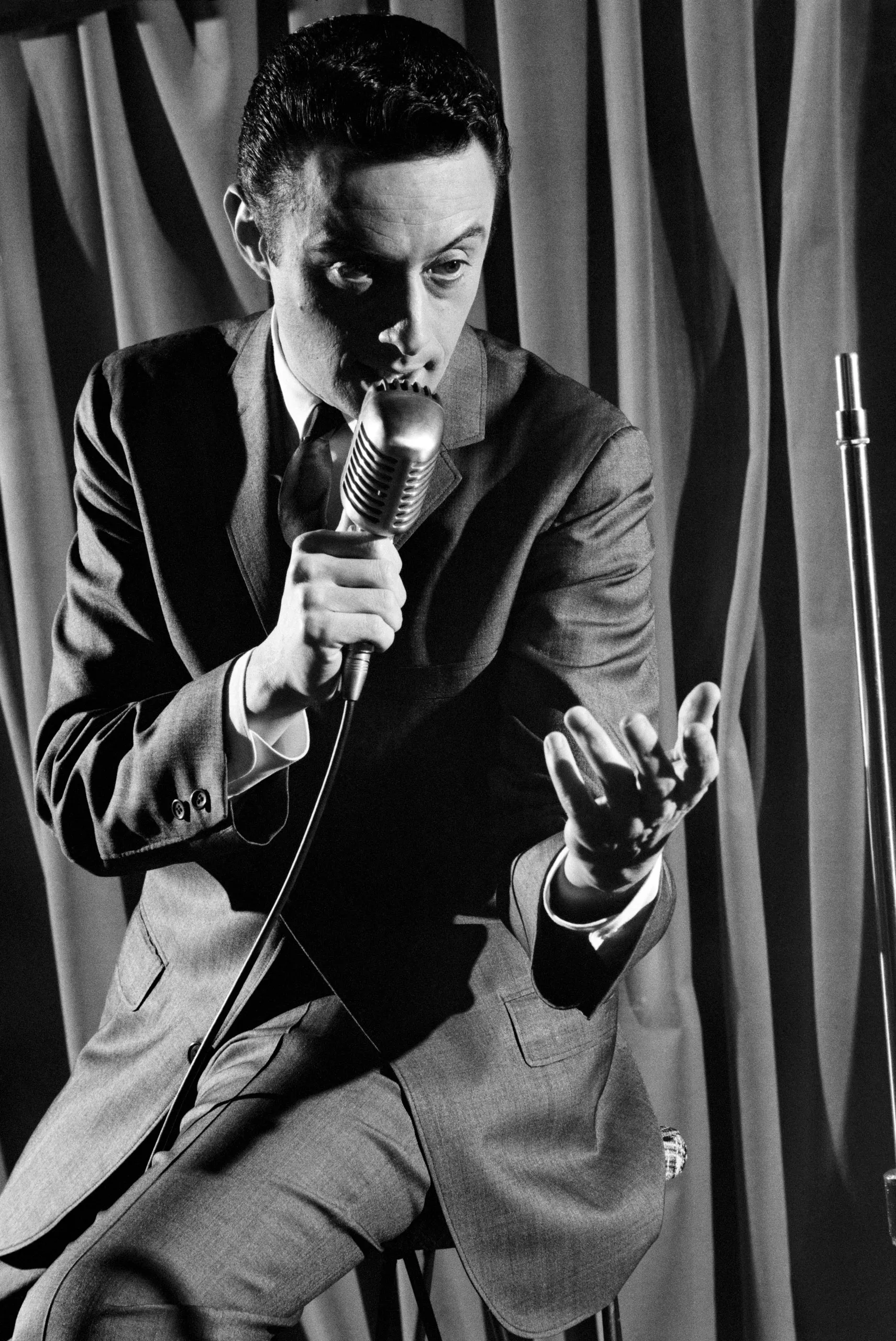 Ο Lenny Bruce σε εμφάνιση στάντ-απ κωμωδίας, στις αρχές της δεκαετίας του 1960. Με τον αυτοσχεδιαστικό, «τζαζ» μονόλογό του και την καυστική κοινωνικοπολιτική σάτιρα, μετέτρεψε τη στάντ-απ κωμωδία σε πεδίο ελευθερίας του λόγου, προκαλώντας τα όρια της λογοκρισίας και οδηγούμενος σε επανειλημμένες συλλήψεις για «άσεμνη» επιτέλεση.