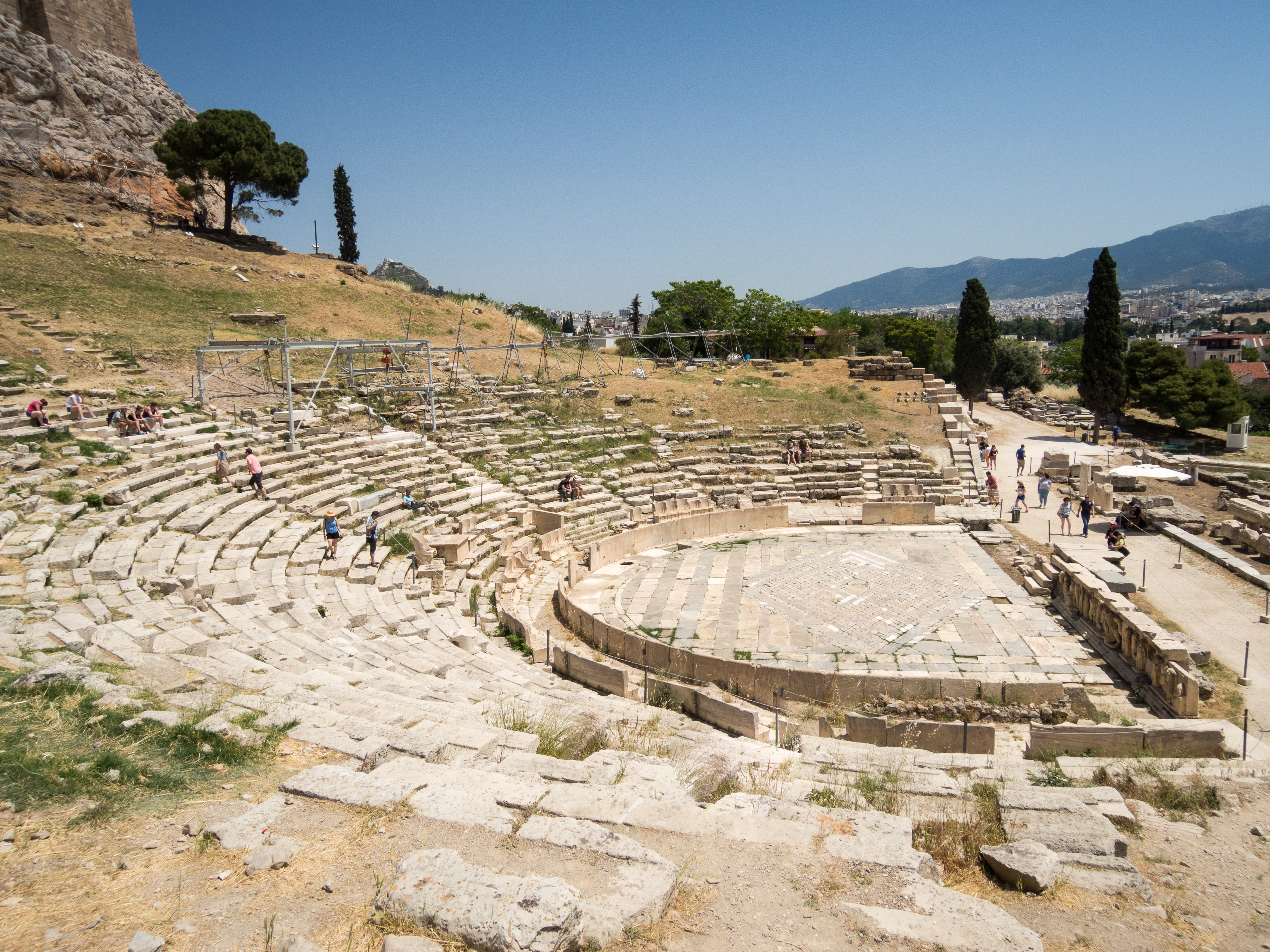 Η ορχήστρα του αρχαίου θεάτρου του Διονύσου. Περί το 61 π.Χ., η χωμάτινη ορχήστρα πλακοστρώθηκε με μαρμάρινο δάπεδο, ενώ προς το τέλος του 4ου αιώνα μ.Χ. τοποθετήθηκε στην περίμετρό της θωράκιο από μαρμάρινες πλάκες για τις μονομαχίες, το οποίο στη συνέχεια αποτέλεσε το πλαίσιο του κολυμβητηρίου.