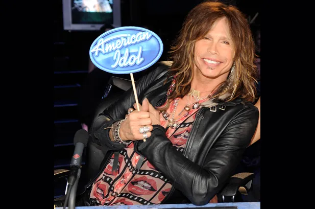Ο [[#Steven Tyler [Στήβεν Τάυλερ]#]], θρυλικός επικεφαλής τραγουδιστής των [[#Aerosmith [Αίροσμιθ]#]] και ιστορική φωνή της σκληρής, σκανδαλιστικής αισθητικής του γκλαμ μέταλ, βρέθηκε στη θέση του κριτή του οικογενειακού τηλεοπτικού διαγωνισμού American Idol κατά τον δέκατο και ενδέκατο κύκλο του (2011–2012), σε μια συμβολική στιγμή όπου η άλλοτε «επικίνδυνη» περσόνα του ροκ σταρ αναβαπτίστηκε σε καλοπροαίρετο μέντορα της δημοφιλούς τηλεόρασης.