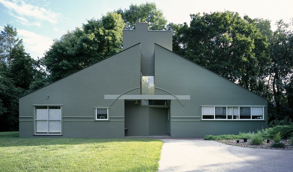 Robert Venturi [Ρόμπερτ Βεντούρι], Vanna Venturi House [Οικία Βάννα Βεντούρι] (1962 – 1964), Chestnut Hill, Φιλαδέλφεια. Το διχασμένο αέτωμα, η υπερμεγέθης καμινάδα και το παιχνίδι με την κλίμακα αντιπαρατίθενται στον λειτουργισμό του μοντερνισμού. Η κατοικία θεωρείται το πρώτο κτίριο του αρχιτεκτονικού μεταμοντερνισμού.